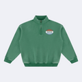 A green long-sleeve quarter-zip sweatshirt with a mock neck collar and a small oval chest graphic, displayed on a solid white background.
