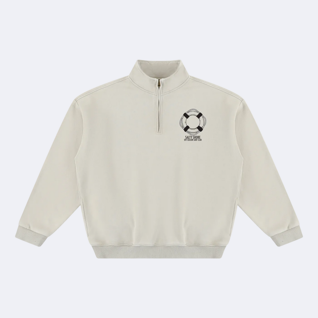 An off-white quarter-zip sweatshirt with a black and white life preserver graphic and the text 'SALTY SHORE' printed on the left chest, displayed on a clean white background.