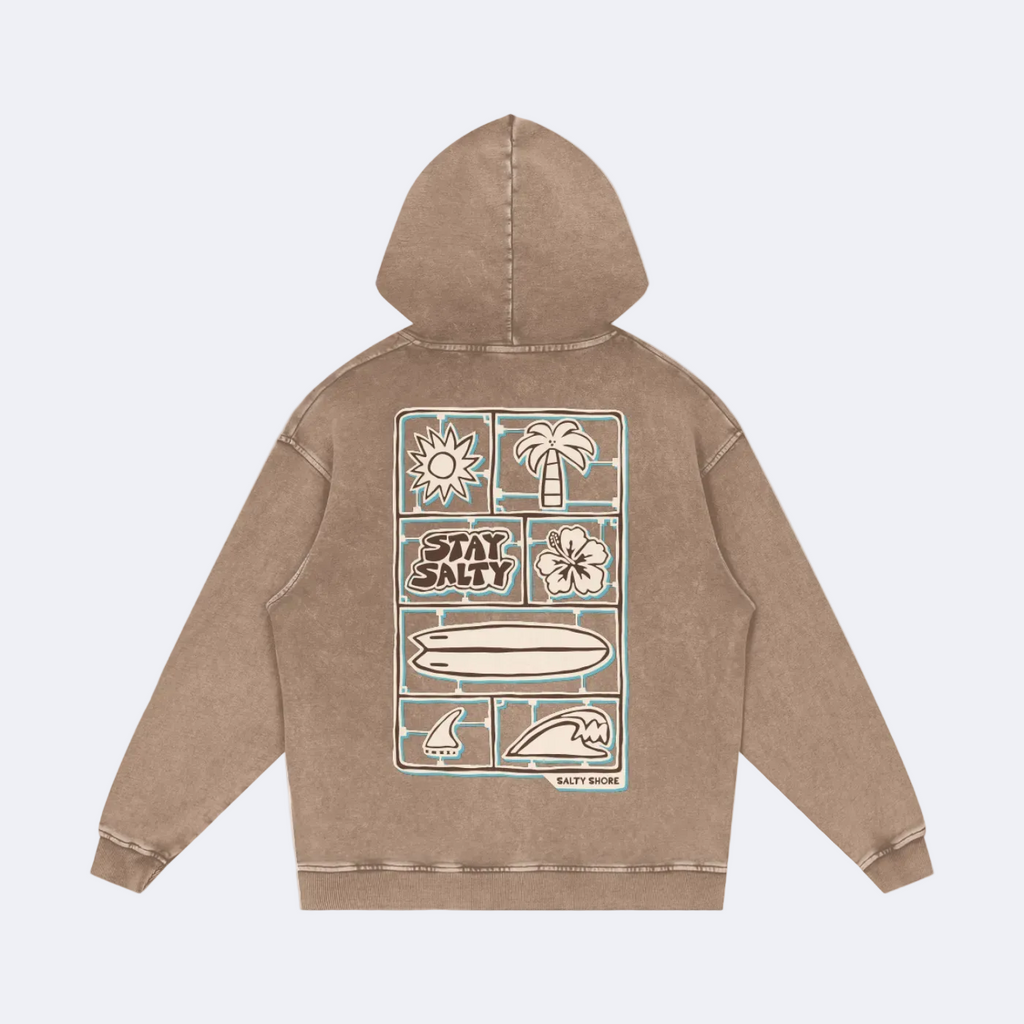 A brown acid-wash hoodie shown from the back, featuring a large graphic print with beach-themed illustrations and the text 'STAY SALTY' on a white background.