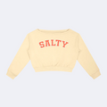 A cream-colored cropped sweatshirt with 'SALTY' printed in coral pink across the chest, displayed flat against a solid white background.