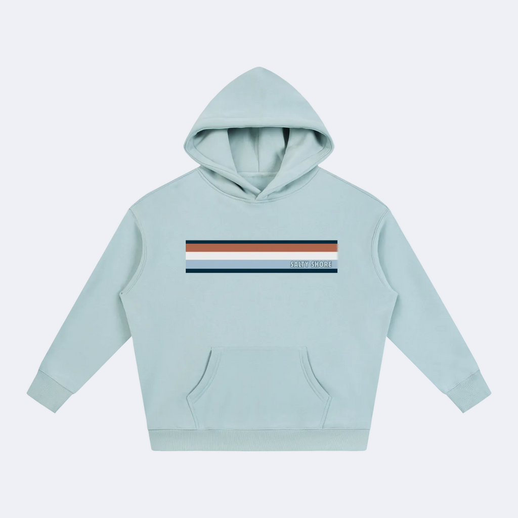 A light blue pullover hoodie with a horizontal stripe graphic across the chest in navy, rust orange, and light blue, featuring the text 'STAY REAL' in white. The hoodie has a front kangaroo pocket and is displayed on a clean white background.